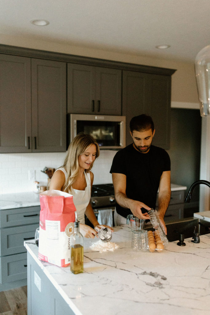 Couple making homemade pasta during in-home Indiana engagement session