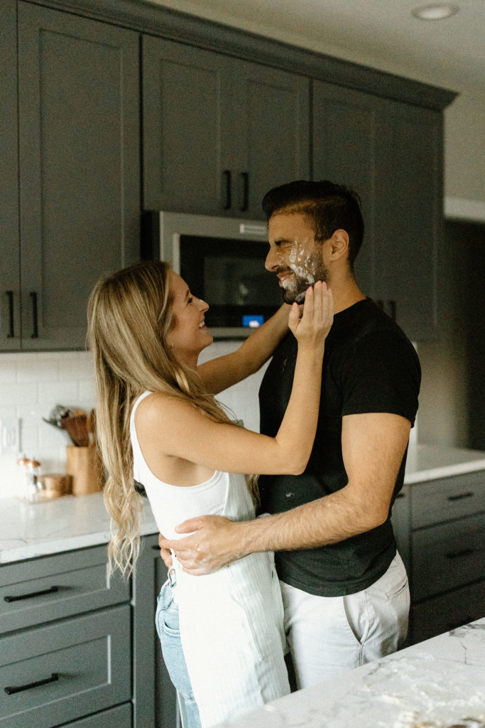 Couple making homemade pasta during in-home Indiana engagement session