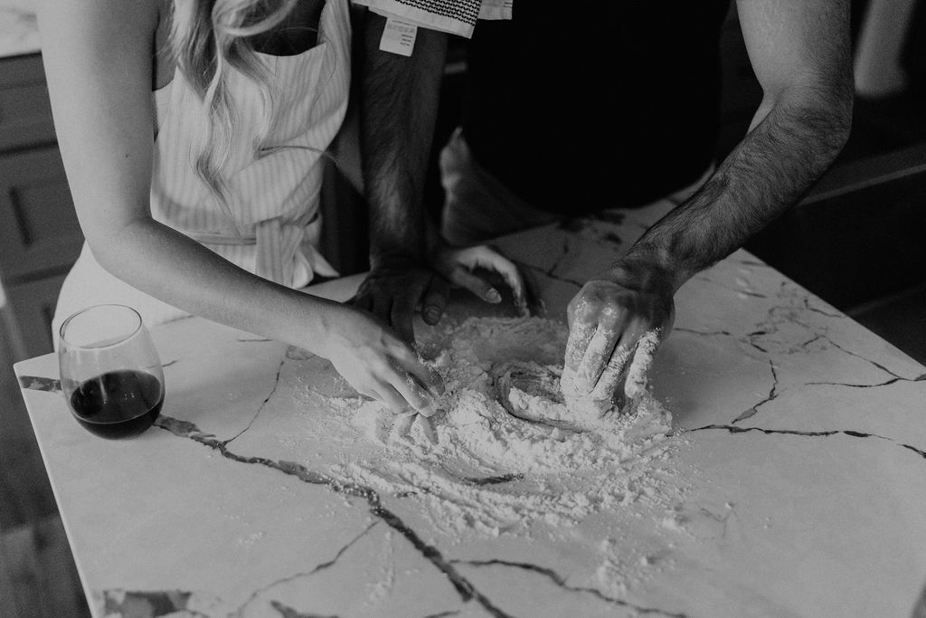 Couple making homemade pasta during in-home Indiana engagement session