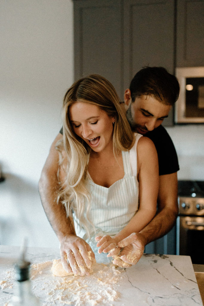 Couple making homemade pasta during in-home Indiana engagement session