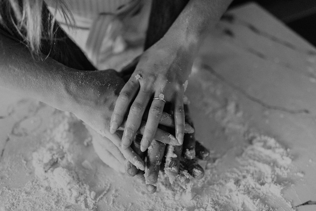 Couple making homemade pasta during in-home Indiana engagement session