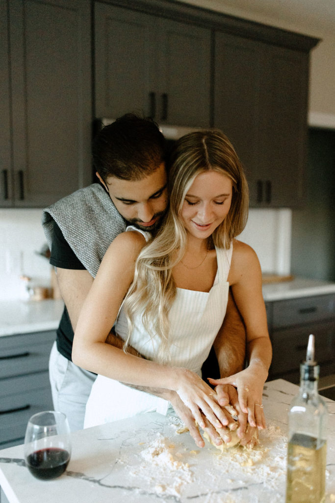 Couple making homemade pasta during in-home Indiana engagement session