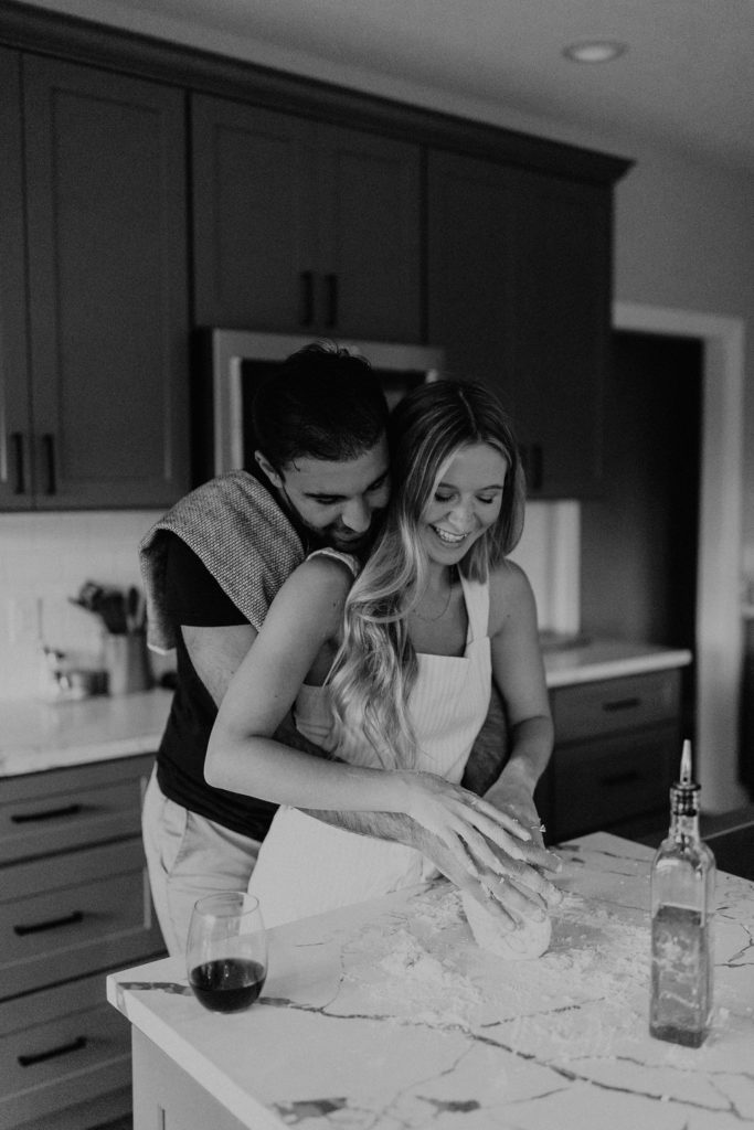 Couple making homemade pasta during in-home Indiana engagement session