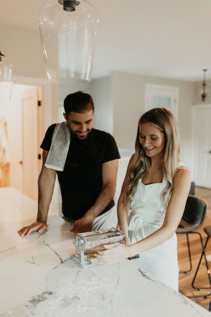 Couple making homemade pasta during in-home Indiana engagement session