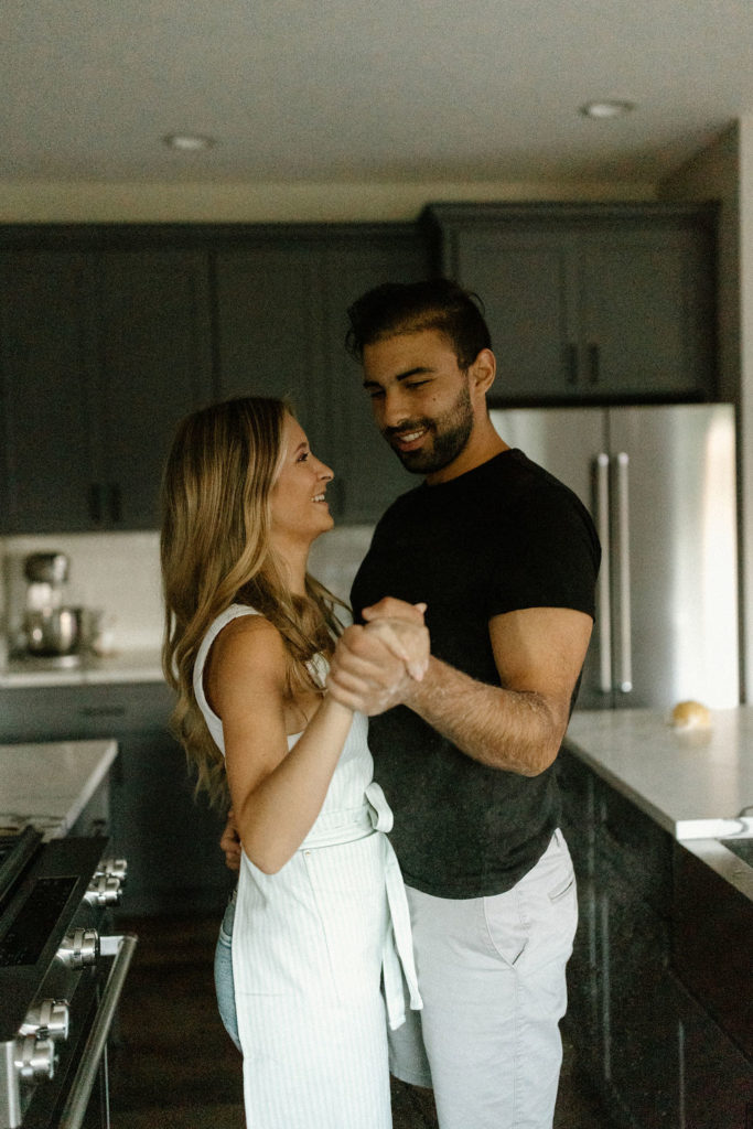 Couple holding hands in kitchen during in home photoshoot