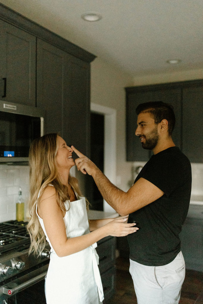 Couple making homemade pasta during in-home Indiana engagement session