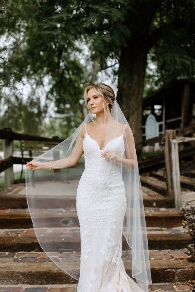 Bride and broom posing for wedding portraits before sage green and white color schemes wedding