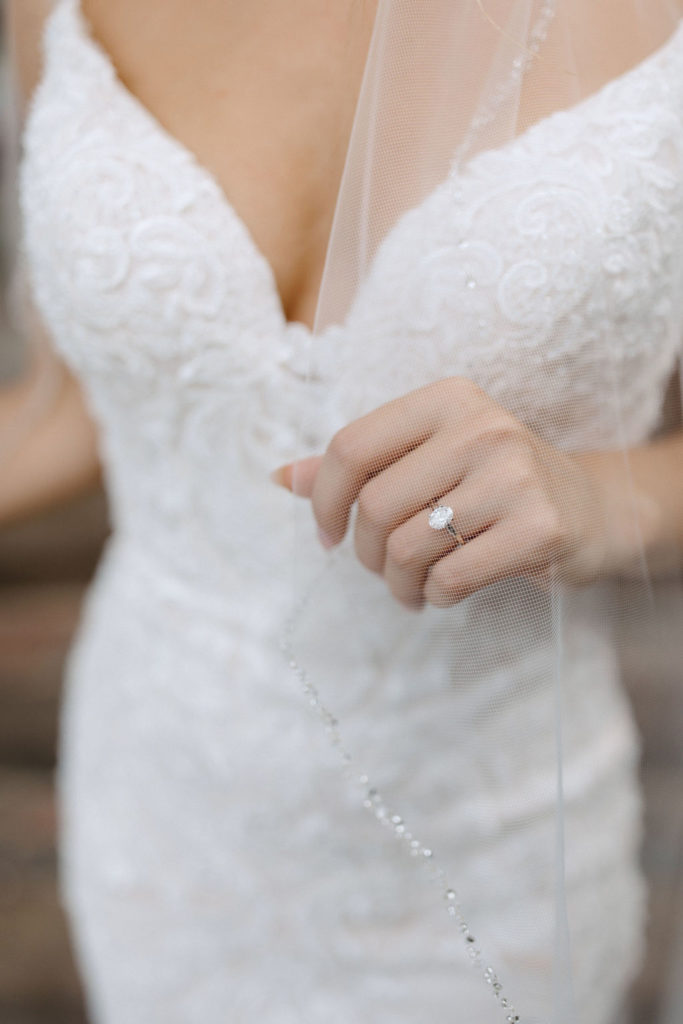 Bride and broom posing for wedding portraits before sage green and white color schemes wedding