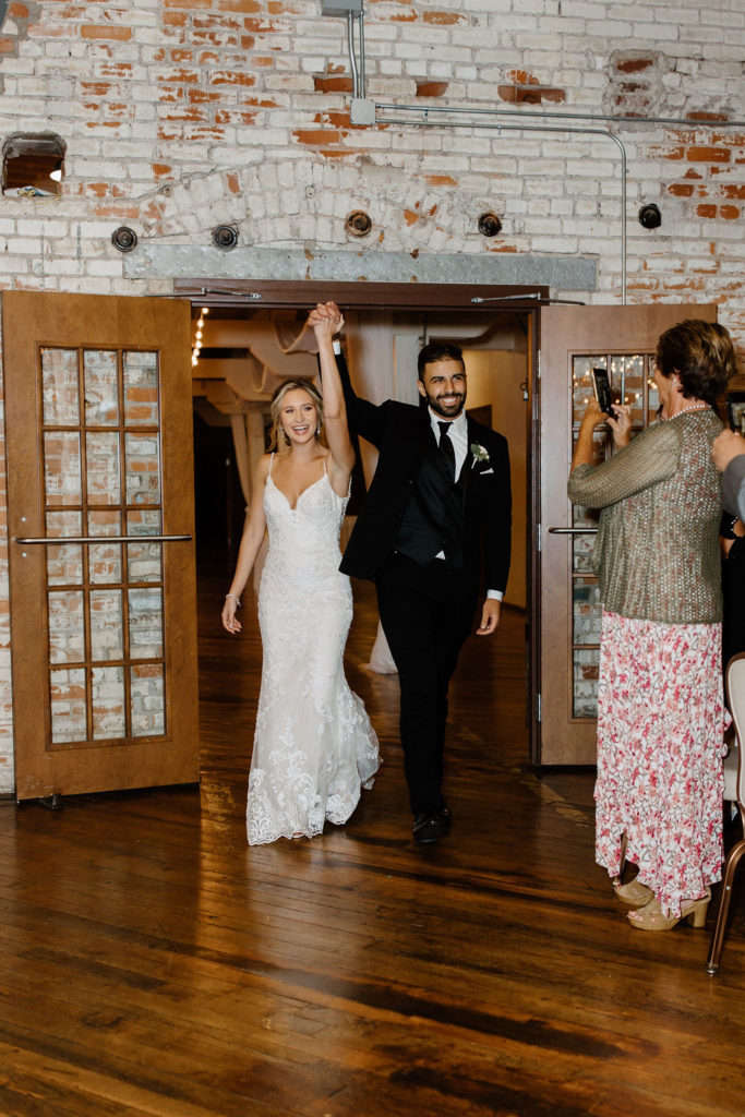 Bride and groom walking into wedding reception