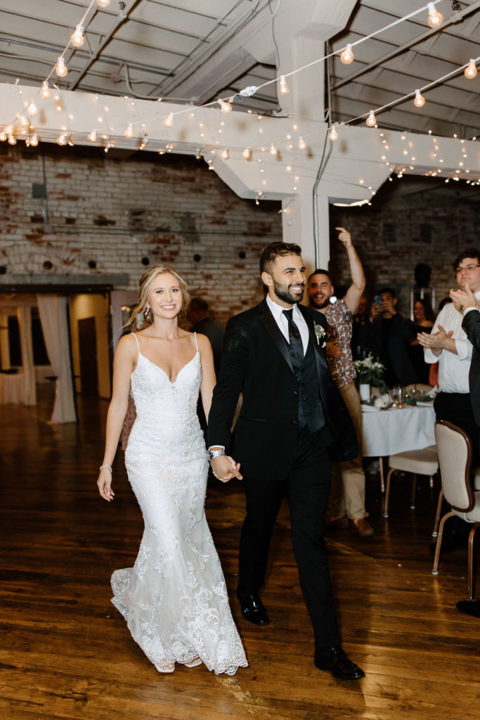 Bride and groom walking into wedding reception