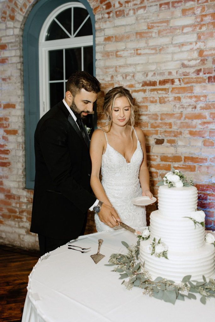 bride and groom cutting wedding cake