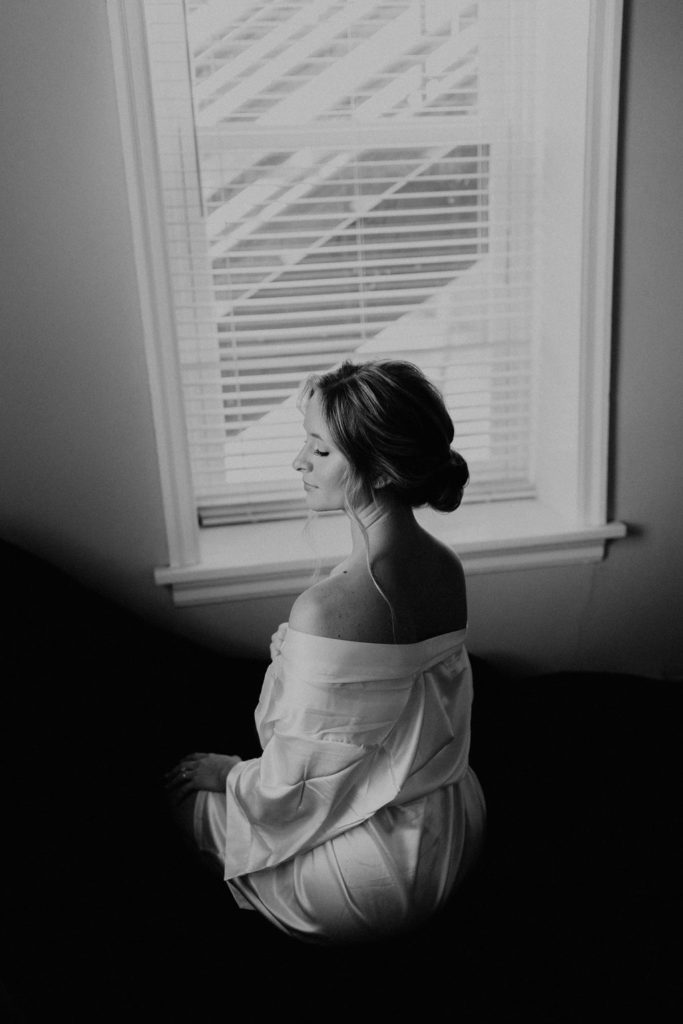 Bride posing in getting ready robe before wedding