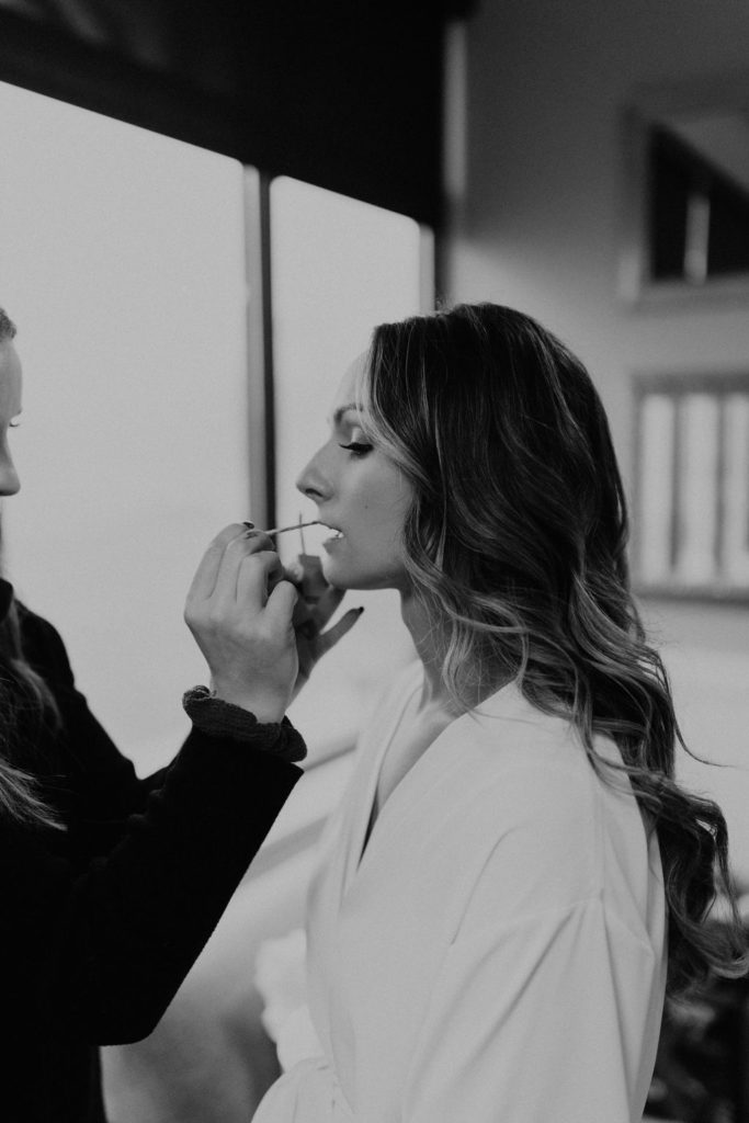 bride getting makeup done before wedding