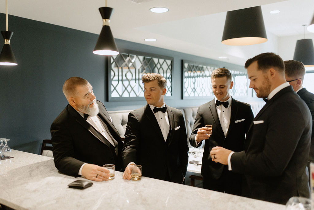 groom and groomsman having a drink before wedding