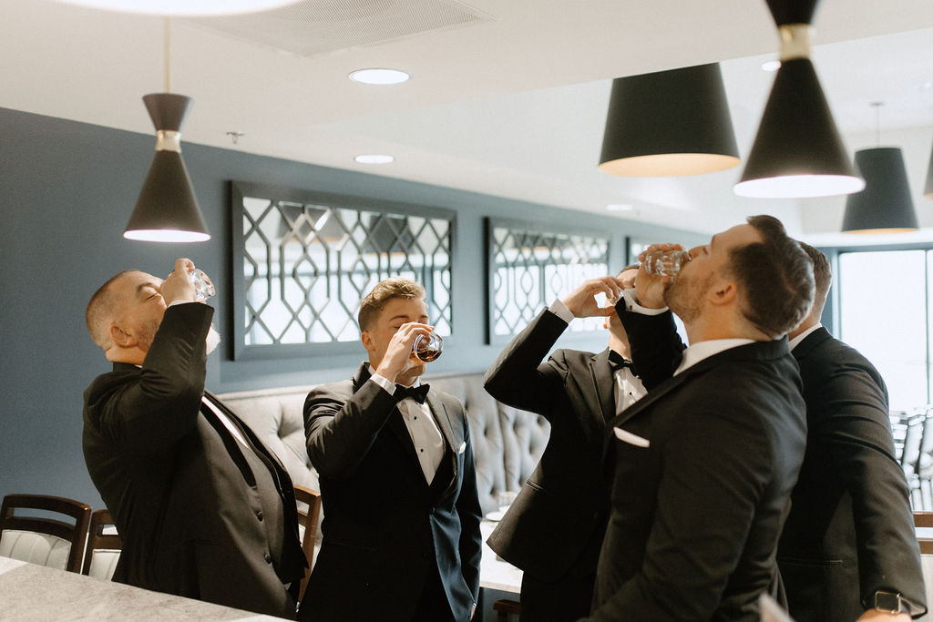 groom and groomsman having a drink before wedding