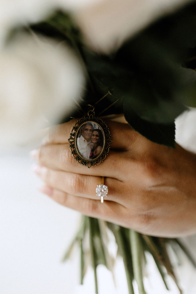 brides weddingring and bouquet detail with family photo