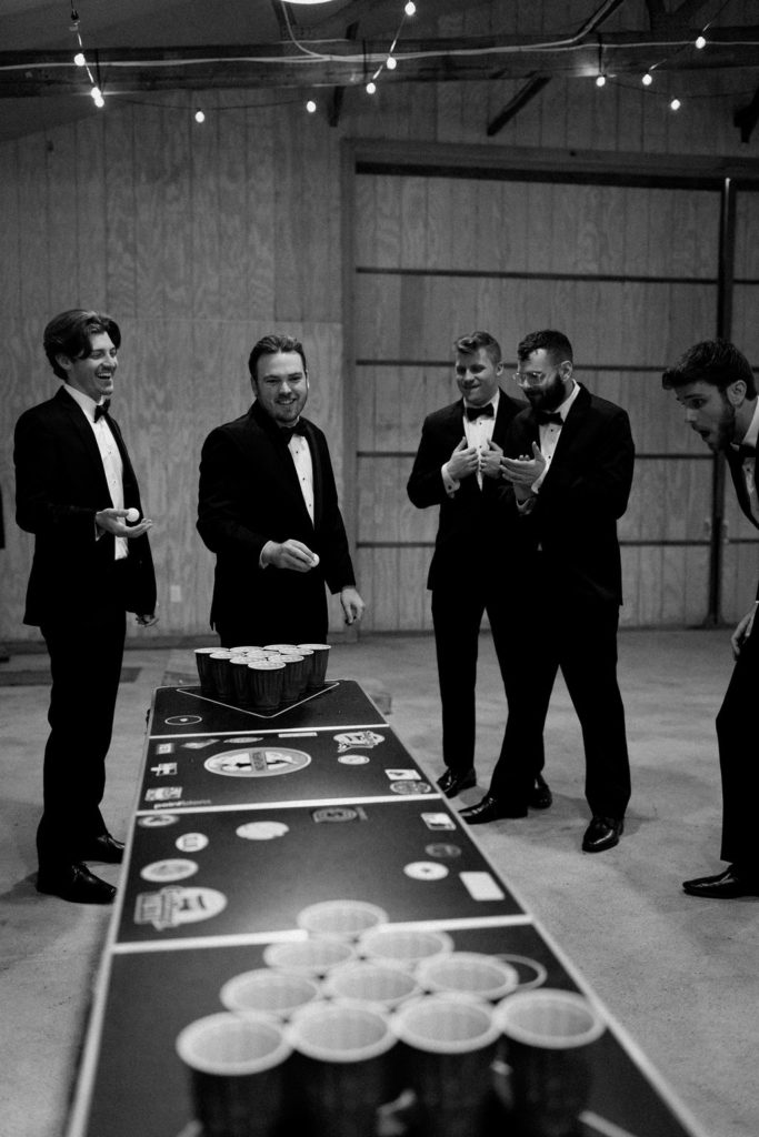 Groom and groomsman playing beer pong