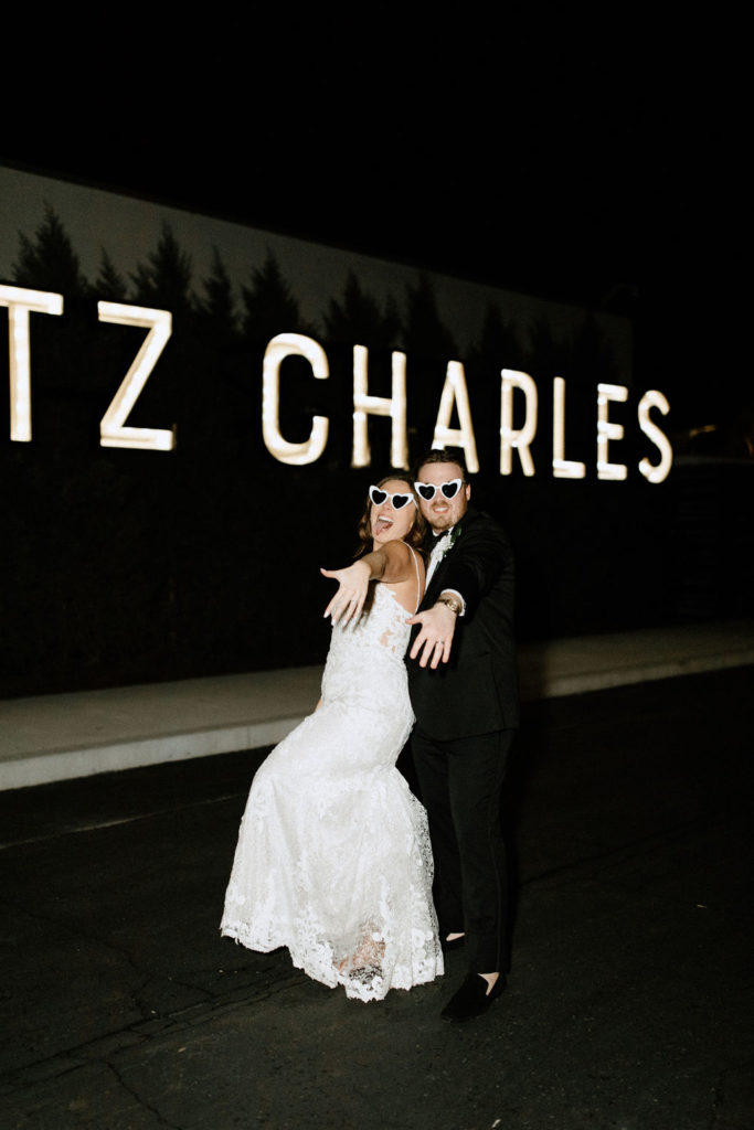 Bride and groom posing in front of Ritz Charles sign in Carmel, Indiana